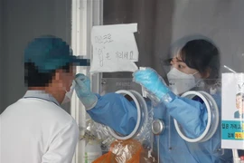 Nhân viên y tế lấy mẫu xét nghiệm COVID-19 cho người dân tại Seoul, Hàn Quốc. (Ảnh: Yonhap/TTXVN)