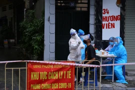 Người dân trong khu vực phong tỏa tạm thời thuộc phường Đồng Nhân được lấy mẫu xét nghiệm ngay trong chiều 24/9. (Ảnh: Hoàng Hiếu/TTXVN)