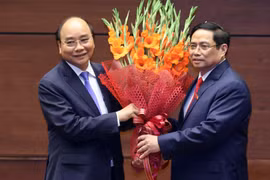 Thủ tướng Phạm Minh Chính tặng hoa Chủ tịch nước Nguyễn Xuân Phúc, Thủ tướng Chính phủ nhiệm kỳ 2016-2021. (Ảnh: Thống Nhất/TTXVN)