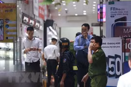 Cảnh sát kiểm tra, khám xét tại cửa hàng điện thoại Nhật Cường mobile ở 33 Lý Quốc Sư, Hà Nội. (Ảnh: Doãn Tấn/TTXVN).
