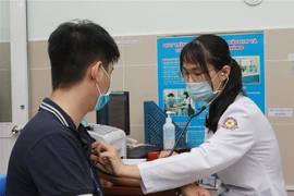 Nhân viên y tế Bệnh viện quận 11, TP.HCM được khám sàng lọc trước khi tiêm vaccine phòng COVID-19. (Ảnh: Đinh Hằng/TTXVN)