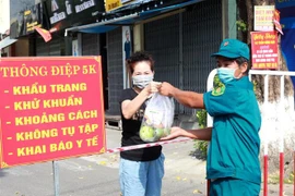 Tiếp tế lương thực cho người dân các khu vực bị phong tỏa. (Ảnh: Lê Ngọc Phước/TTXVN)