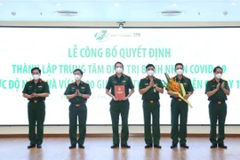 Trung tướng Ngô Minh Tiến trao Quyết định thành lập Trung tâm điều trị bệnh nhân COVID-19 mức độ nặng và vừa thuộc Bệnh viện Quân y 175. (Ảnh: Hồng Pha/TTXVN phát)