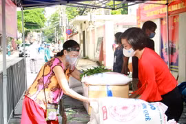 Phó Chủ tịch Liên hiệp các tổ chức hữu nghị thành phố Hà Nội Trần Thị Phương (phải) trao quà hỗ trợ cho người dân phường Phúc Xá. (Ảnh: Nguyễn Cúc/TTXVN)