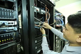 Nhân viên VNPT Bình Phước xử lý kỹ thuật tại phòng Tổng đài, hệ thống truyền dẫn. (Ảnh: Minh Quyết/TTXVN)