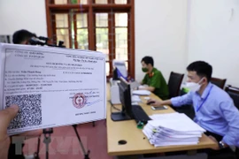 Tiếp nhận và xét duyệt hồ sơ của các cá nhân, đơn vị có nhu cầu cấp giấy đi đường theo mẫu mới. (Ảnh: Phạm Kiên/TTXVN)