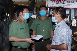 Đại tá Đinh Văn Nơi, Giám đốc Công an tỉnh An Giang,thăm hỏi, động viên và hỗ trợ cho gia đình ông Đỗ Thành Thọ. (Ảnh: Công Mạo/TTXVN)