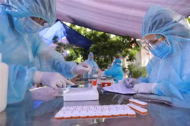 Nhân viên y tế lấy mẫu xét nghiệm COVID-19 cho người dân ở phường Tây Mỗ, quận Nam Từ Liêm, Hà Nội. (Ảnh: Vũ Sinh/TTXVN)