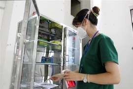 Bác sỹ Lê Thị Bảo Yến, Trưởng Trạm y tế lưu động số 1, kiểm tra các loại thuốc phục vụ cho người mắc COVID-19 tại Trạm y tế lưu động số 1 (phường 11, quận 3). (Ảnh: Thanh Vũ/TTXVN)