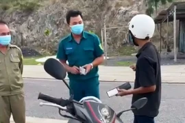 Cán bộ tổ công tác liên ngành phường Vĩnh Hòa, thành phố Nha Trang, tỉnh Khánh Hòa thu giữ giấy tờ của một công dân. (Ảnh từ video)