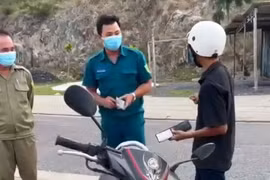Cán bộ tổ công tác liên ngành phường Vĩnh Hòa, thành phố Nha Trang, tỉnh Khánh Hòa thu giữ giấy tờ của một công dân. (Ảnh từ video)