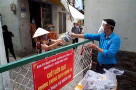 Liên đoàn Lao động quận Bình Thạnh trao quà cho người lao động trong khu vực phong tỏa. (Ảnh: Thanh Vũ/TTXVN)