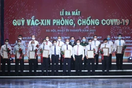  Đại diện các tập đoàn, tổng công ty, doanh nghiệp trao ủng hộ Qũy vaccine phòng COVID-19. (Ảnh: Dương Giang/TTXVN)