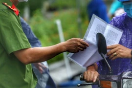 Kiểm tra giấy đi đường của người dân. (Nguồn: TTXVN)