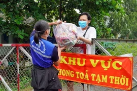 Trao túi an sinh cho người dân đăng ký qua chương trình SOS. (Ảnh: Xuân Khu/TTXVN)