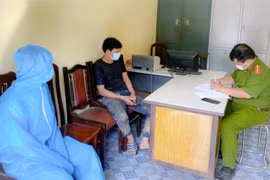 Lã Tiến Đ. (áo đen) tại cơ quan Công an huyện Ba Chẽ (Quảng Ninh). (Ảnh: TTXVN phát)