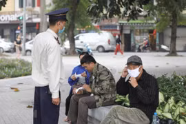 Nhắc nhở người dân đeo khẩu trang nơi công cộng. (Ảnh: Minh Quyết/TTXVN)
