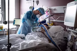 Nhân viên y tế điều trị cho bệnh nhân COVID-19. (Ảnh: AFP/TTXVN)