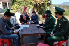 Cán bộ, chiến sỹ biên phòng tuyên truyền, vận động người dân ký cam kết tham gia tố giác người xuất nhập cảnh trái phép. (Ảnh: Đức Hiếu/TTXVN)