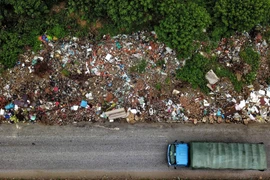 'Bãi rác khổng lồ' nằm dưới chân cầu vượt xã An Khánh (Hoài Đức, Hà Nội) nhìn từ trên cao. (Ảnh: Thành Đạt/TTXVN)