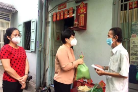 Trao hỗ trợ cho người dân bị ảnh hưởng vì dịch COVID-19. (Ảnh: Thanh Vũ/TTXVN)