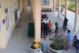 Nhóm người lạ xông vào trường Trung học Phổ thông Đốc Binh Kiều với thái độ hung hăng, bắt và khống chế nam học sinh lớp 12CB5 lên xe rời khỏi trường. (Ảnh: TTXVN phát)