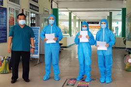 Bác sỹ Lê Thành Phúc trao giấy chứng nhận khỏi bệnh cho BN3396, BN3397, BN3398. (Ảnh: Văn Dũng/TTXVN)