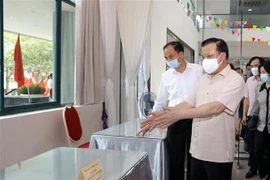 Bí thư Thành ủy Hà Nội Đinh Tiến Dũng kiểm tra công tác bầu cử và công tác phòng, chống dịch bệnh COVID-19 tại Khu vực bỏ phiếu số 8, phường Phú Thượng, quận Tây Hồ, Hà Nội. (Ảnh: Nguyễn Điệp/TTXVN)