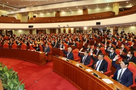 Các lãnh đạo Đảng, Nhà nước và các đại biểu biểu quyết thông qua chương trình Hội nghị. (Ảnh: Trí Dũng/TTXVN)