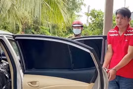 Đối tượng Nguyễn Văn Thắng (áo đỏ) cùng phương tiện bị lực lượng chức năng tạm giữ. (Ảnh: Công Mạo/TTXVN)