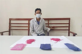 Sùng A Thái và tang vật vụ án. (Ảnh: TTXVN phát)