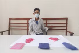 Sùng A Thái và tang vật vụ án. (Ảnh: TTXVN phát)