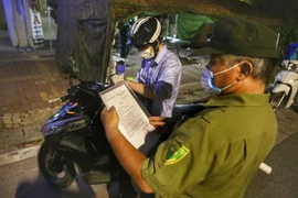 Công an thành phố Hà Nội kiểm tra giấy đi đường của người dân. (Nguồn: TTXVN)