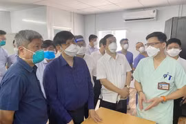 Bộ trưởng Bộ Y tế nghe báo cáo công tác thu dung, điều trị của Bệnh viện Hữu nghị Việt Đức tại Bệnh viện Dã chiến số 13. (Ảnh: TTXVN phát)