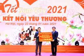 Bí thư Thành ủy Hà Nội Vương Đình Huệ trao biển tượng trưng 5.000 suất quà tặng người lao động Thủ đô. (Ảnh: Nguyễn Cúc/TTXVN)