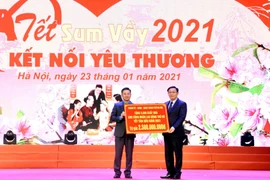 Bí thư Thành ủy Hà Nội Vương Đình Huệ trao biển tượng trưng 5.000 suất quà tặng người lao động Thủ đô. (Ảnh: Nguyễn Cúc/TTXVN)