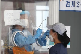 Nhân viên y tế lấy mẫu xét nghiệm COVID-19 cho người dân tại Seoul, Hàn Quốc, ngày 1/8/2021. (Ảnh: Yonhap/TTXVN)
