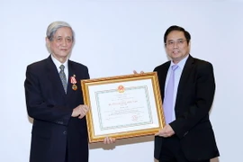 Ông Phạm Minh Chính, Ủy viên Bộ Chính trị, Bí thư Trung ương Đảng, Trưởng Ban tổ chức Trung ương trao tặng Huân chương Độc lập hạng Nhất cho ông Hồ Tiến Nghị. (Ảnh: An Đăng/TTXVN)