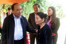 Phó Thủ tướng Chính phủ Nguyễn Xuân Phúc thăm gia đình bà Nguyễn Thị Hồng Lê ở thôn 1, xã Trà Mai, huyện Nam Trà My. (Ảnh: Đỗ Trưởng/TTXVN)