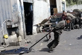 Một cậu bé Syria 12 tuổi phải làm các công việc nặng nhọc để kiếm sống tại một xưởng cơ khí ở thủ đô Damascus ngày 10/3. (Nguồn: AFP/TTXVN)