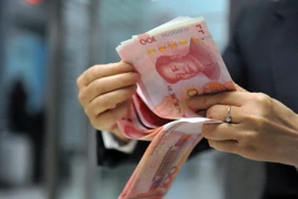 Nhân viên ngân hàng kiểm tiền 100 nhân dân tệ tại một ngân hàng ở Hàng Châu, tỉnh Chiết Giang, miền đông Trung Quốc ngày 1/12. (Nguồn: AFP/TTXVN)