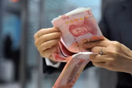 Nhân viên ngân hàng kiểm tiền 100 nhân dân tệ tại một ngân hàng ở Hàng Châu, tỉnh Chiết Giang, miền đông Trung Quốc ngày 1/12. (Nguồn: AFP/TTXVN)