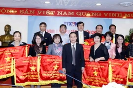 Ông Nguyễn Đức Lợi, Ủy viên Trung ương Đảng, Bí thư Đảng ủy, Tổng Giám đốc TTXVN trao tặng Cờ Thi đua cho các đơn vị. (Ảnh: An Đăng/TTXVN)