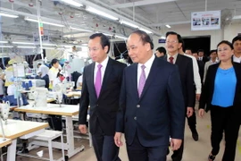 Phó Thủ tướng Nguyễn Xuân Phúc thăm phân xưởng may của Công ty. (Ảnh: Trần Lê Lâm/TTXVN)