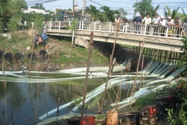 Huy động 21 máy bơm liên tục bơm nước chống hạn tại điểm cầu Hộ trên kệnh Champeaux, xã Tân Thành, Gò Công Đông, Tiền Giang. (Ảnh: Minh Trí/TTXVN)
