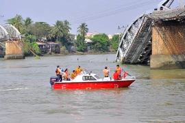 Lực lượng chức năng tiến hành khảo sát hiện trường trước khi tiến hành trục vớt. (Ảnh: Công Phong/TTXVN)