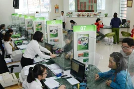 Giao dịch tại Vietcombank. (Ảnh: CTV/Vietnam+)