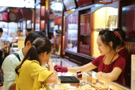 Giao dịch vàng tại Bảo Tín Minh Châu. (Ảnh: Vietnam+)
