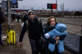 Người dân sơ tán khỏi thành phố Irpin, phía Tây Bắc Kiev, Ukraine ngày 7/3. (Ảnh: AFP/TTXVN)