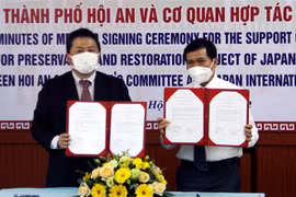 Ông Nguyễn Văn Sơn, Chủ tịch Ủy ban Nhân dân thành phố Hội An, trao đổi văn bản ký kết hỗ trợ với ông Shimizu Akira, Trưởng Đại diện Văn phòng JICA Việt Nam. (Ảnh: Trịnh Bang Nhiệm/TTXVN)